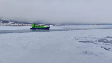 Hovercraft rapidly rushing through snowy ice field of winter lake. slow motion. Stock Footage 230212044