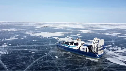 Hovercraft ship rides on clear cracked blue ice. Winter lake Baikal. Video stock 170578046