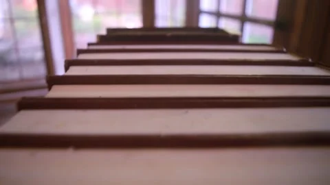 Hovering above a row of red encyclopedias in a dimly lit sunroom Video stock 338205056