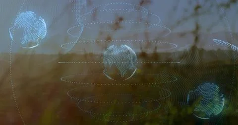Hovering central wireframe globe projecting dotted orbital rings over grassy Stock Photos