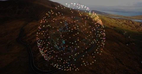 Hovering data globe floating above hillside and distant water, with winding road Stock Photos