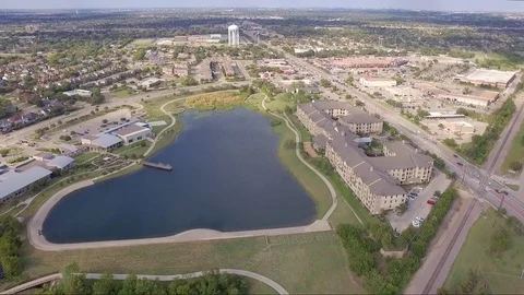 Hovering Drone Pan Down on Lake and Lakeside Apartment Complex Stock Footage 76382212