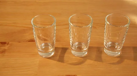 Hovering over 3 shot glasses Stock Footage 49997646