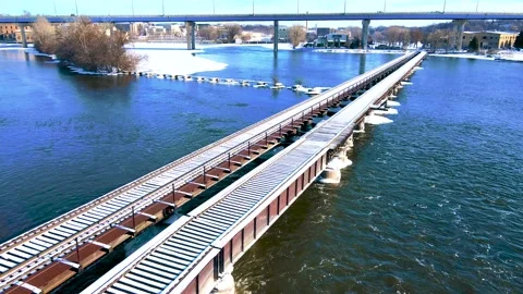 Hovering over a old railroad bridge over a cold river Stock Footage 169976114