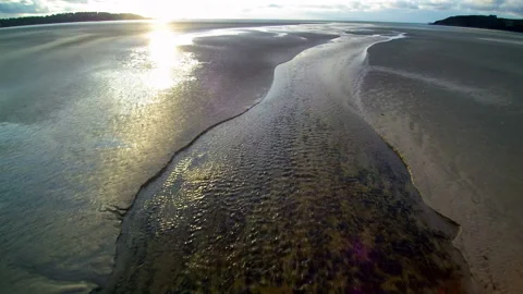 Hovering over a stream on a large beach at dusk to the seashore. Cloudy weather. Stock Footage 150552321