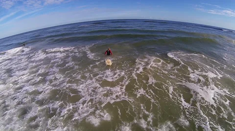 Hovering over water while surfer finds wave St. Augustine FL Aerial Stock Footage 34542360