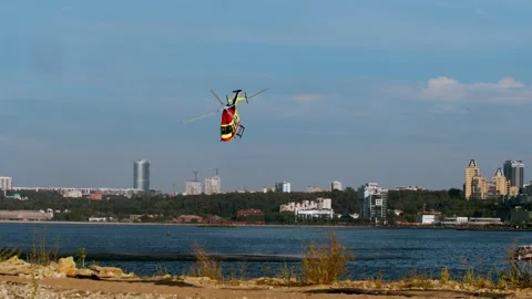 Hovering in sky above river and urban landscape, medical helicopter receives Stock Footage 314379690