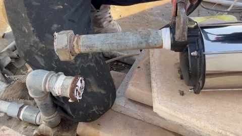 How to Align and Connect Metal Pipes to a Water Pump Stock Footage 345611762