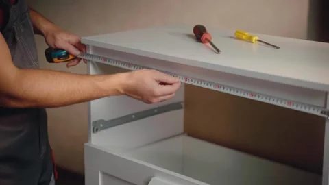 How to assemble a simple drawer unit step by step in a modern living space Stock Footage 294912412