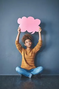 How can I make this work. Studio shot of a young woman holding a thought bubble Stock Photos