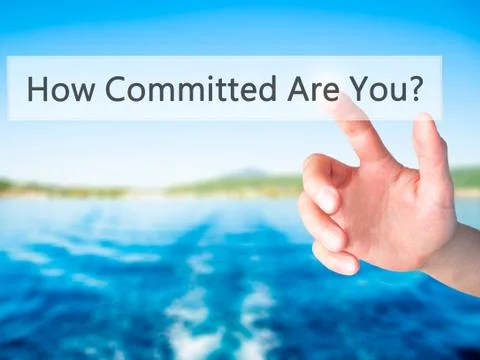 How Committed Are You - Hand pressing a button on blurred background concept  Stockfoto's