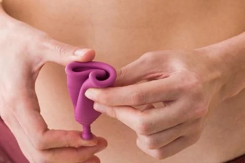 How to fold a menstrual cup closeup. Latin female ecological feminine hygiene Stock Photos