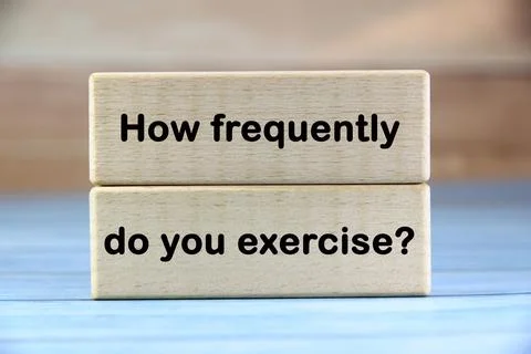 How frequently do you exercise? wording  or text on wood block with blue ba.. Stock Photos
