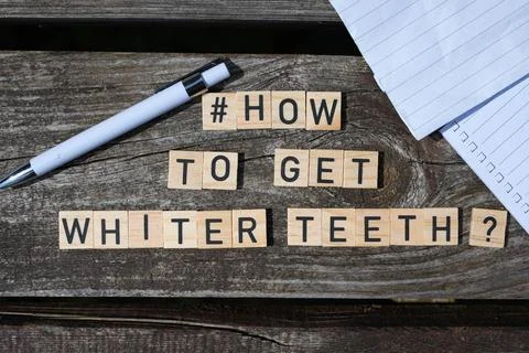How to get whiter teeth question letters on wooden blocks on a wooden table Stock Photos