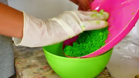 How to make colored powder, holi Festival. The hands are salting food colorin Stock Footage 83473014