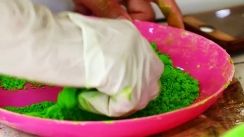 How to make colored powder, holi Festival. The hands are salting food colorin Stock Footage 83473480