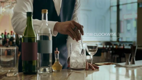 How to make a Martini Part 5 of 7: A male bartender stirs all the ingredients cl Video stock 199455658