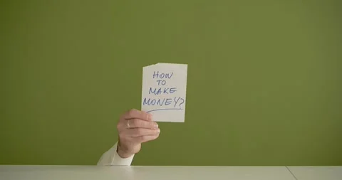 "How to make Money" The man's mini picks up a sheet where it is written  Stock Footage 267090579