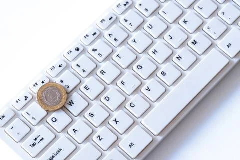 How much do programmers in Argentina earn or a peso coin lies on the key with Stock Photos