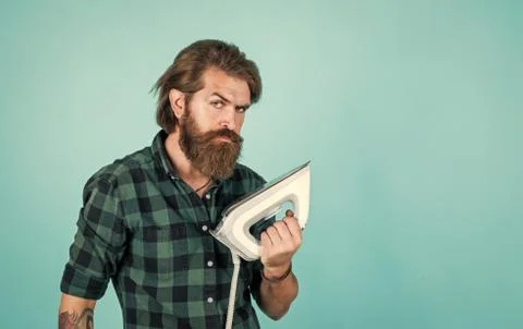 How to use it. man concentrated on ironing a shirt. laundry room at home Stock Photos