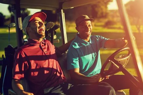 This is how we roll. two golfers riding in a cart on a golf course. Stock Photos