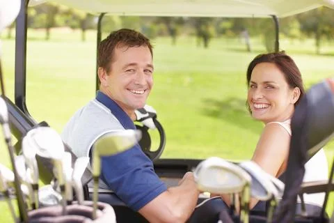 This how we like to spend our weekends. Happy couple in a golf cart on the green Fotos de archivo
