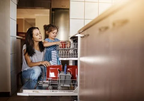 This is how we stack the dishwasher. Shot of a cute little girl and her mother Foto stock