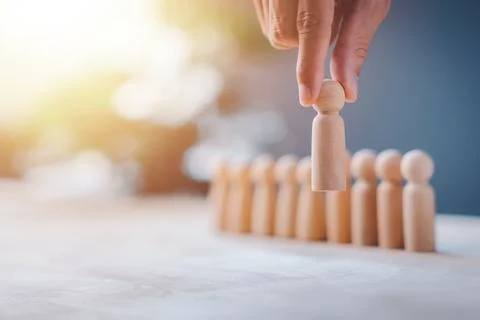 HR manager (human resources) or Employer hand choose takes person wooden do.. Stock Photos