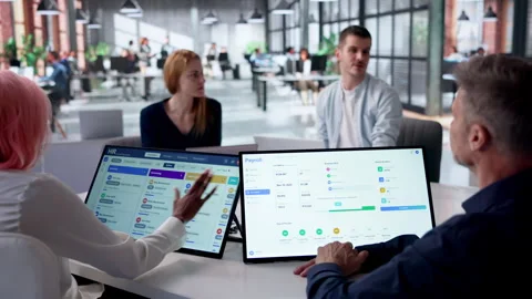 HR Manager Reviews Payroll Software On Tablet During Team Meeting 스톡 동영상 332497792