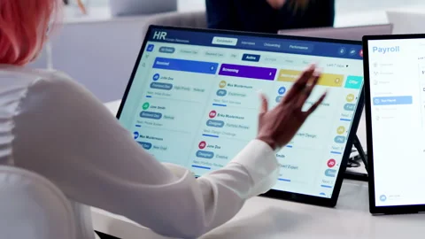 HR Manager Reviews Payroll Software On Tablet During Team Meeting 스톡 동영상 332498348