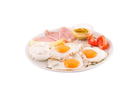 Hree fried eggs garnished with cheese, ham and tomatoes Stock Photos