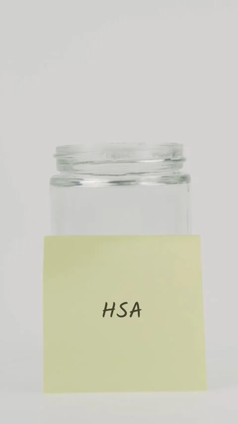 HSA text or word on yellow sticky note attached to glass jar with hand Stock Footage 311742781