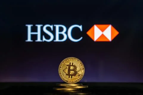 HSBC logo on a computer screen with a stack of Bitcoin cryptocurency coins. Stock Photos