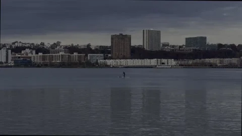 Hudson River Paddle Boarder rowing downstream as seen from Riverside Park Stock Footage 257480243