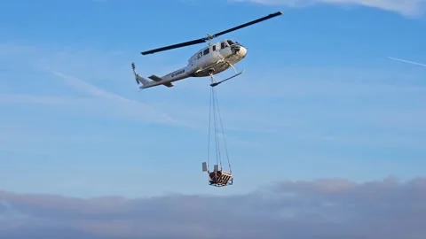 Huey Helicopter air lifting aggregate Cam Brow, Forest of Bowland, Stock Footage 306223569
