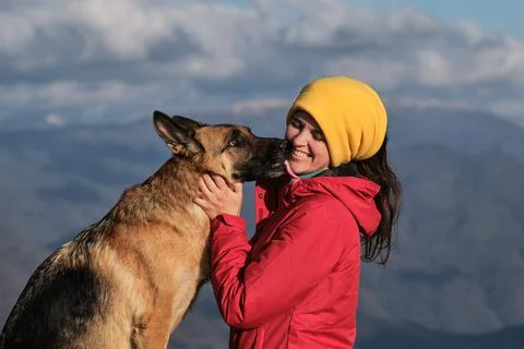 Hug and kiss best friend in nature. Young pretty Caucasian woman in red jacke Stock Photos