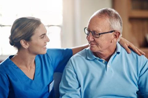 Hug, talking and old man with nurse on sofa for support, comfort and assist.. Stock Photos