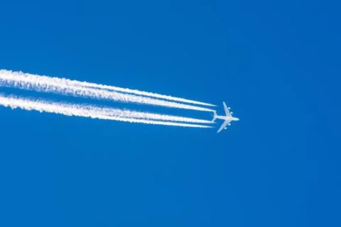 Huge airplane big four engines aviation airport contrail clouds. 写真素材