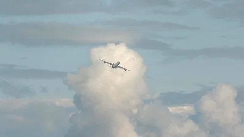 Huge airplane flying distant view turning beautiful clouds behind Video stock 94758946