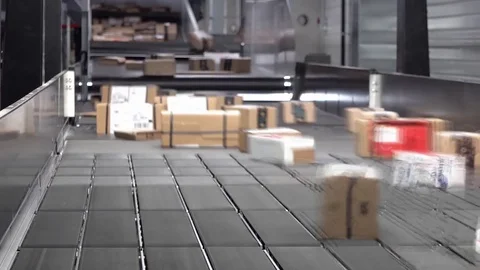 Huge amount of parcels bein transported on conveyor belts with motion blur Stockbeeldmateriaal 83638944