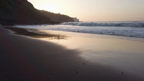 Huge atlantic ocean waves slowly covering wide beach with volcanic sand during Video stock 123043901