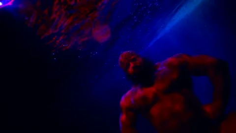 A huge bald man with a beard demonstrates the muscles of arms and chest in blue Stock Footage 181811230