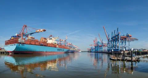 Huge blue cargo ship container cranes in Hamburgs harbour at hot summer day Stock Photos