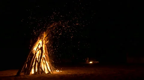 A huge bonfire on the sand and a small fire in the background. Lots of sparks Stock Footage 65304086