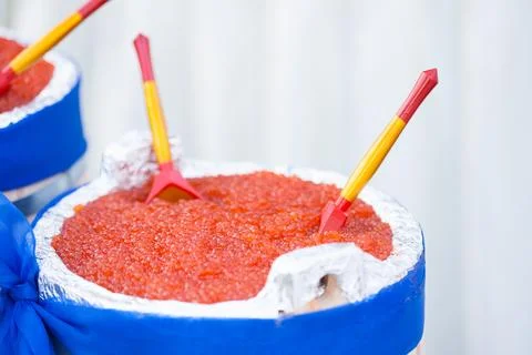 Huge bucket of red caviar on table Photos