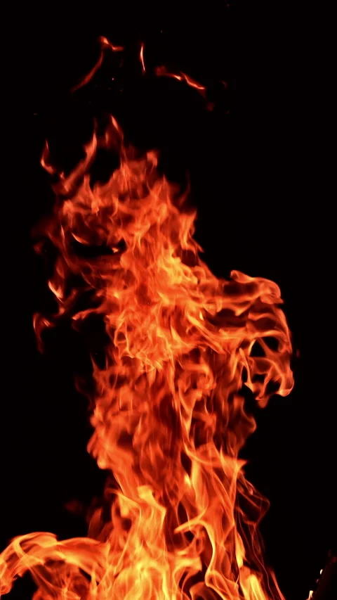 Huge burning fire with tiny sparkles flying up quickly.  Video stock 308586944