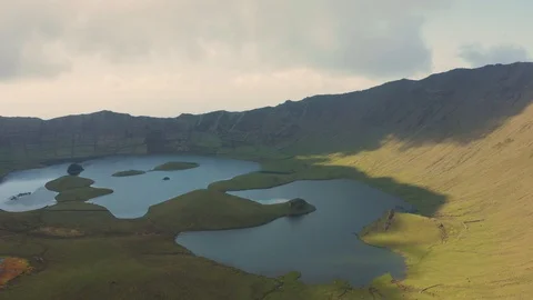 Huge caldera of Corvo volcano. Panoramic aerial shot of green slopes and lake Stockbeeldmateriaal 119600464