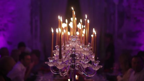 A huge candlestick in a restaurant. Festive table with a large group of people Stock Footage 141751155