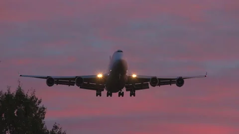 Huge cargo airplane boeing 747 jumbo jet arrival red night sky front view Stock Footage