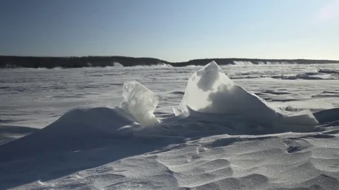 Huge chunk of ice shining on the snowy area on a sunny day Stock Footage 79796164